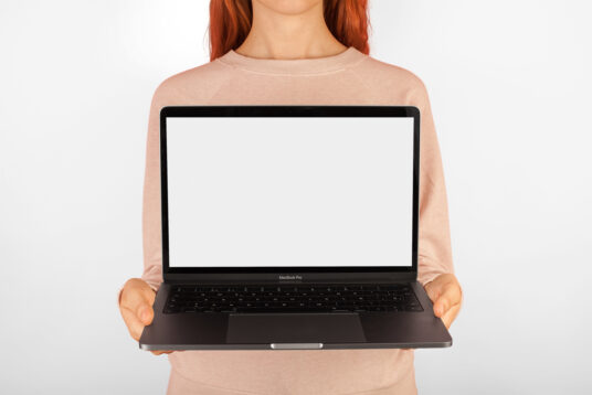 Молодая женщина показывает генератор макетов дисплея MacBook Pro скачать Мокап